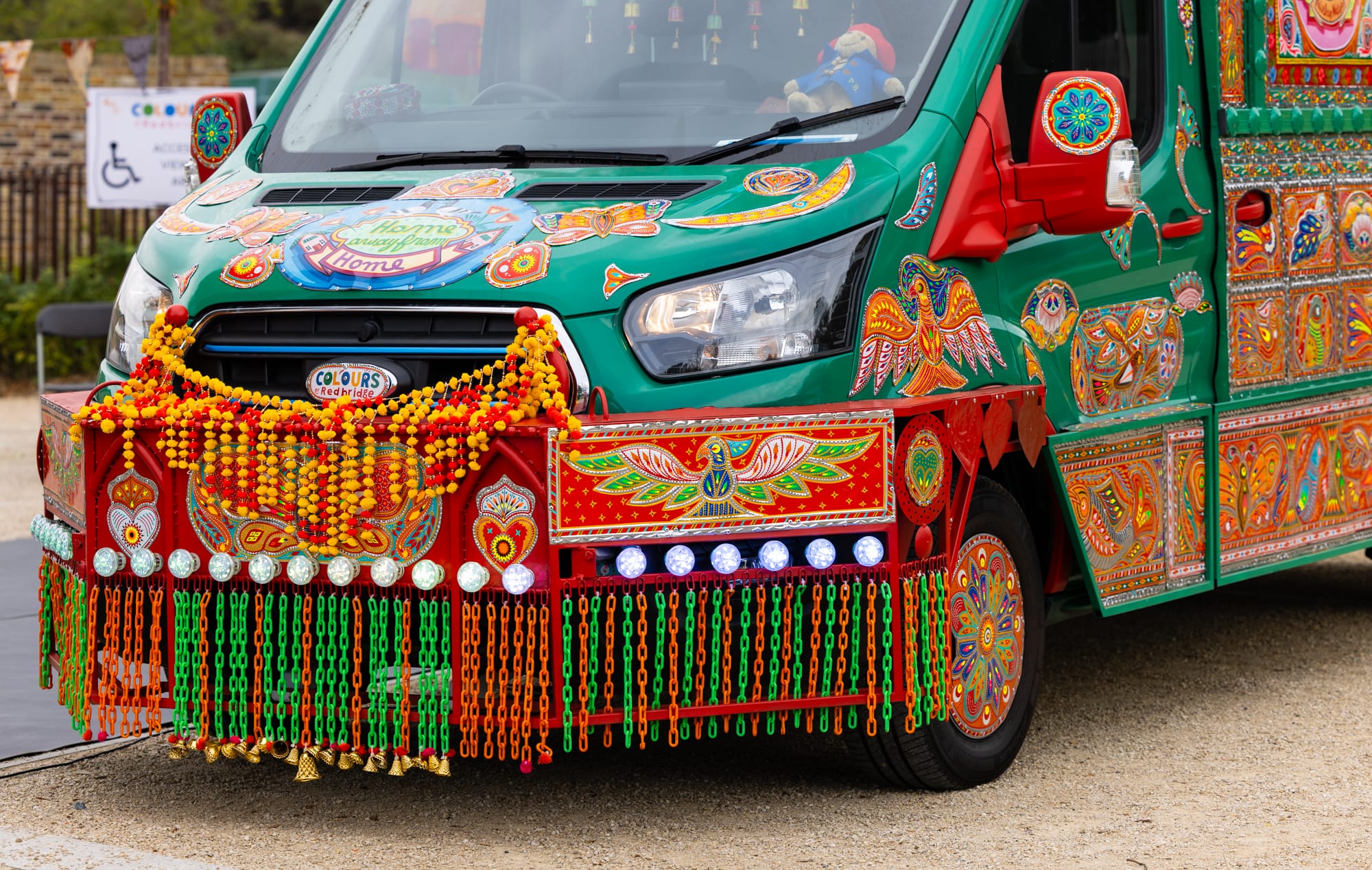 a detail of the front of a colorful van that has been transformed into an artwork