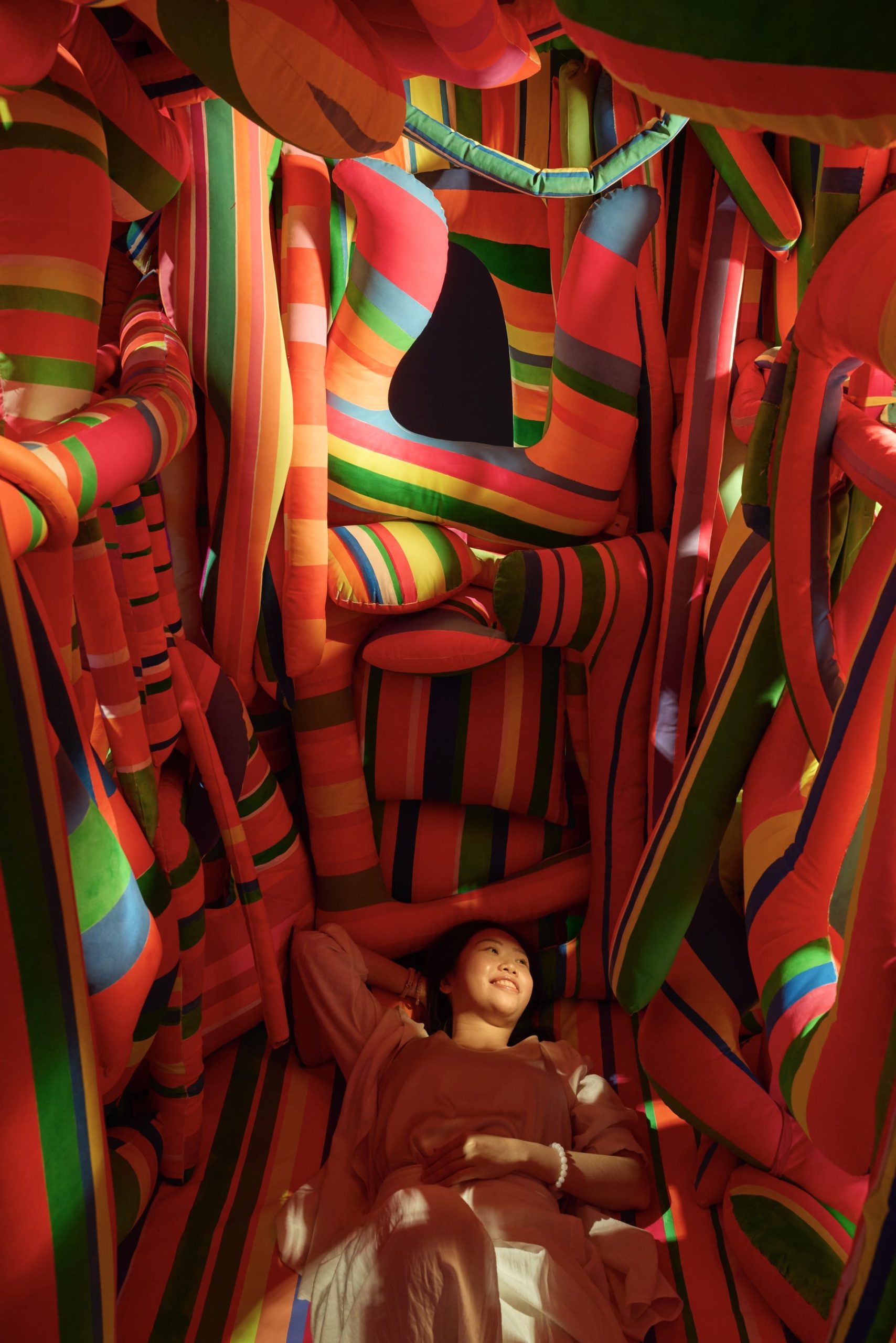a vibrant cushion structure with a person lying inside
