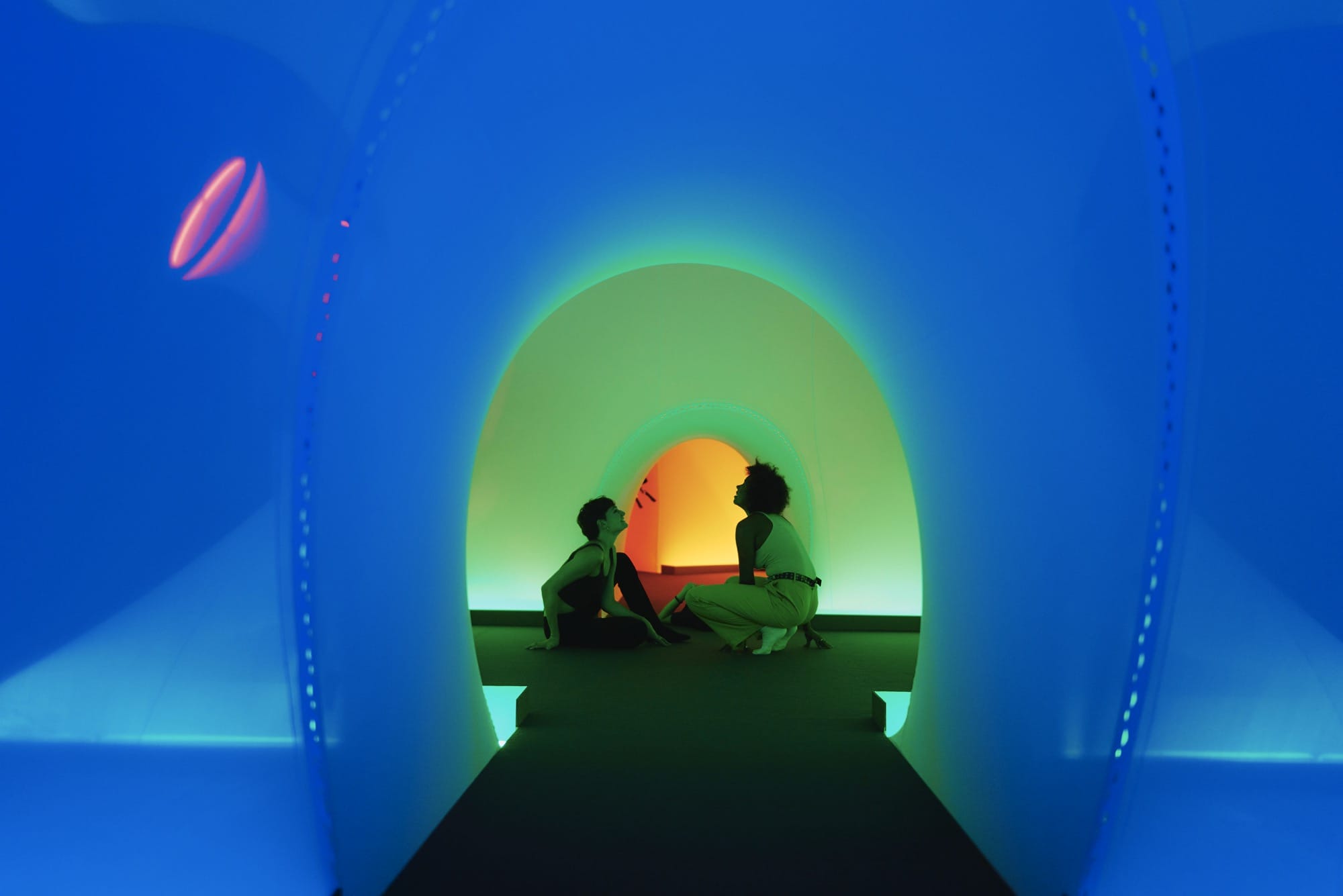 children sit in a vibrant glowing environment
