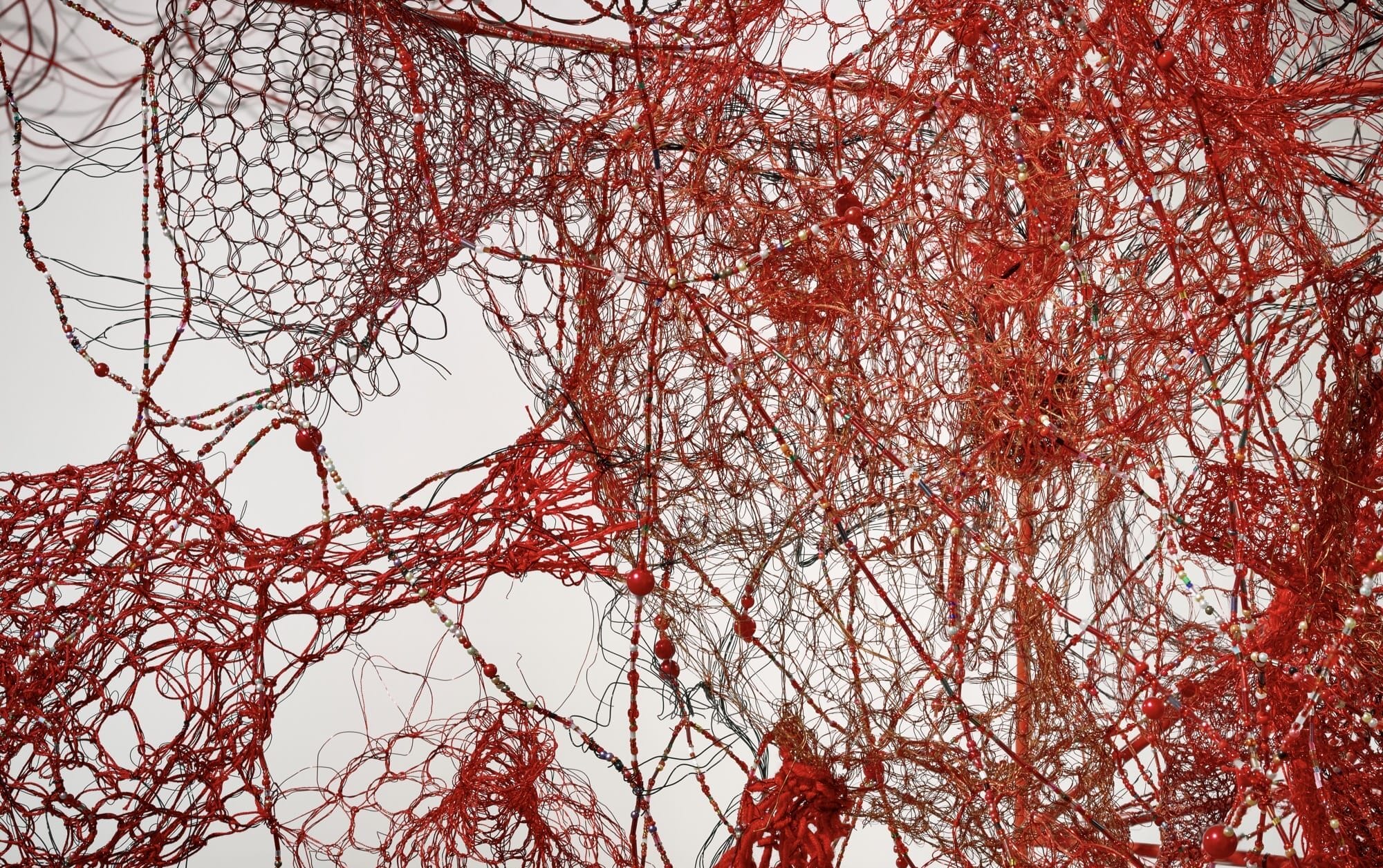 a detail of red fiber in an installation by Chiharu Shiota