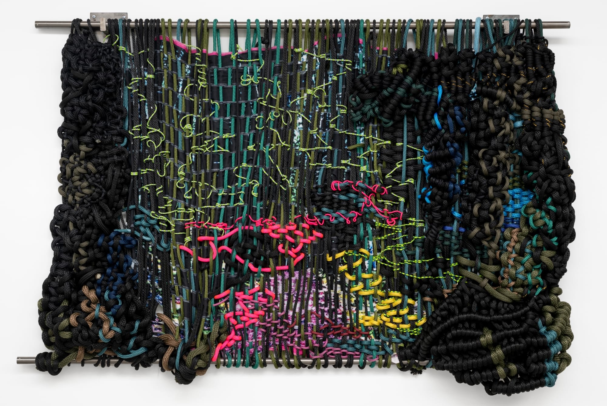 a knotted rope work by Jacqueline Surdell hanging from a bar