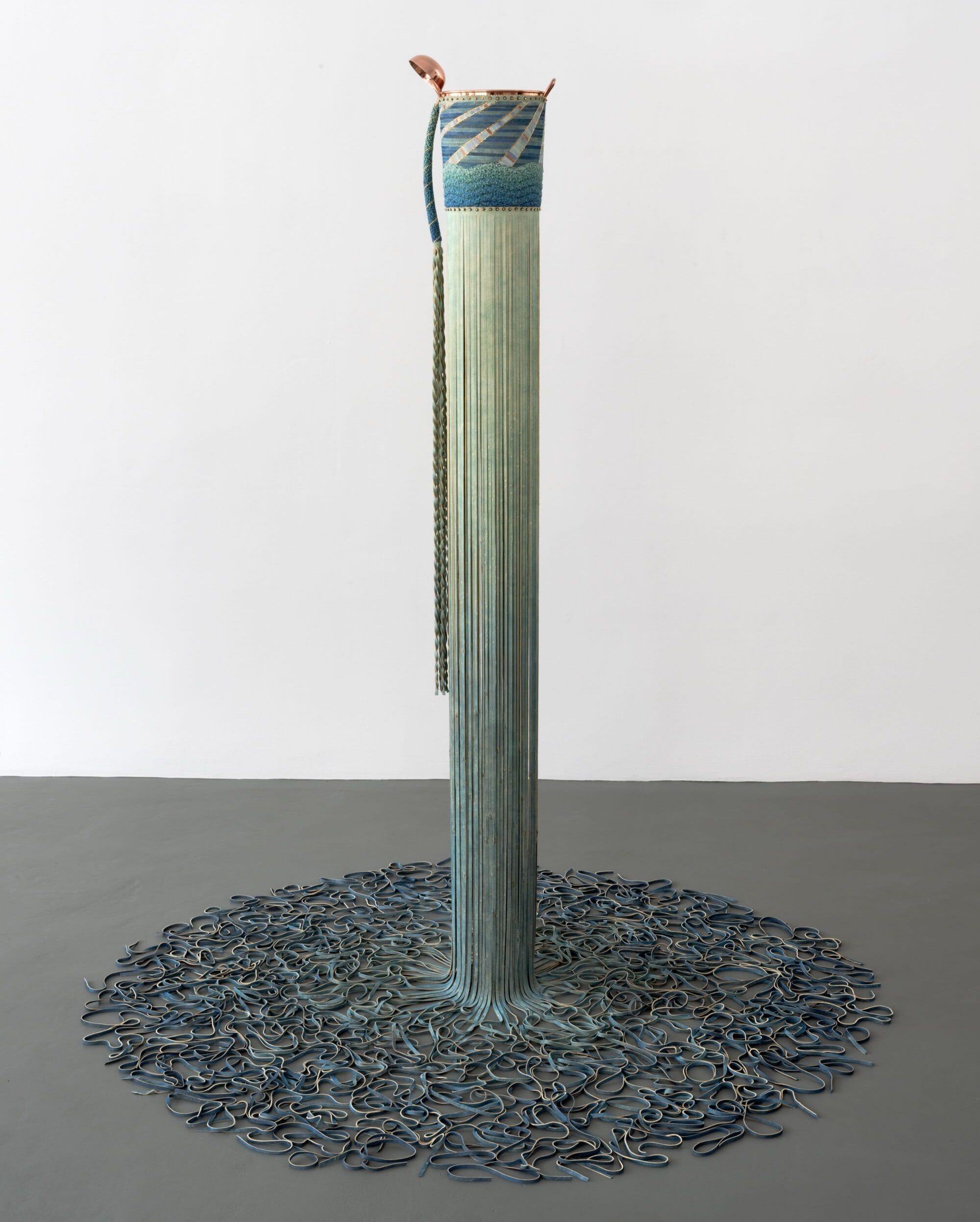 a columnar, beaded, leather, and metal sculpture by Dyani White Hawk