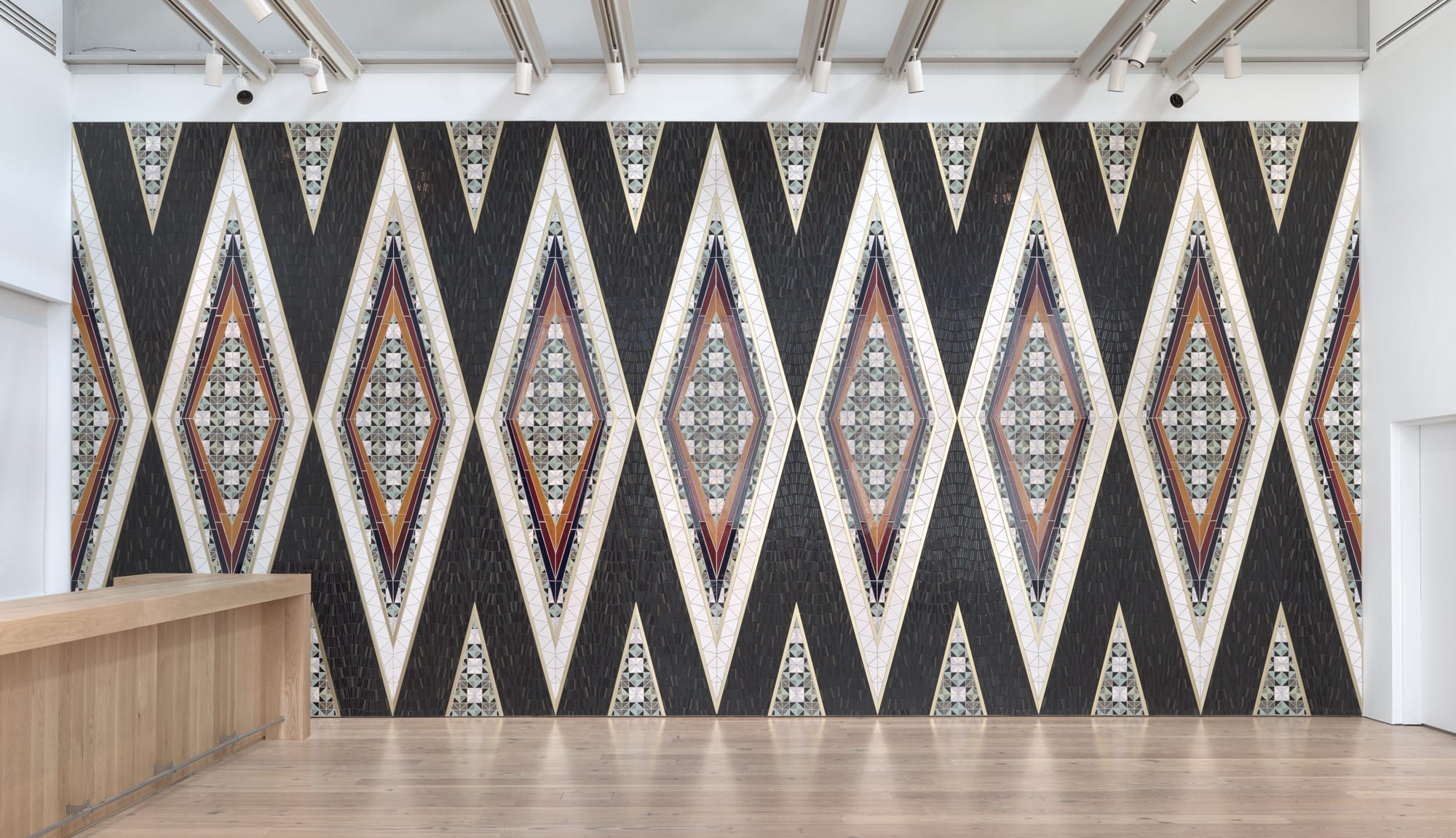 a geometric patterned wall installation by Dyani White Hawk of a Native American pattern